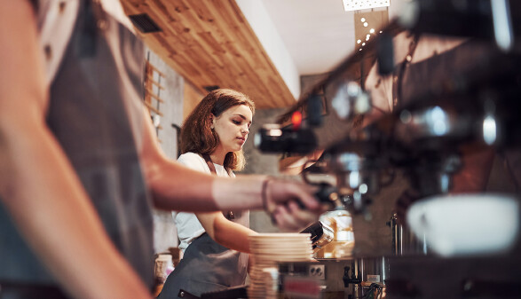 Service-Mitarbeiterin bedient Kaffeemaschine
