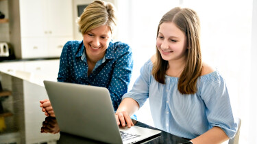 Mutter und Tochter sitzen vor einem Laptop
