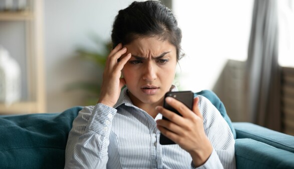 Frau schaut besorgt auf ihr Smartphone