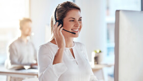 Junge lachende Frau in einem Callcenter