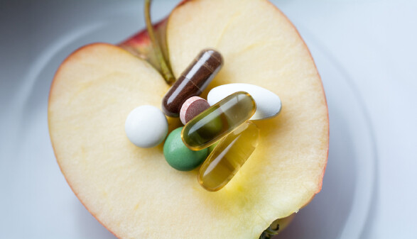 Nahrungserg&auml;nzung - Pillen,Tabletten und Kapseln auf einem Apfel