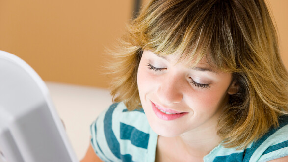 Junge Frau schaut in eine Tageslichtlampe