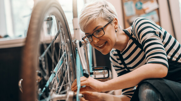 Frau repariert Fahrrad