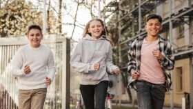 3 Jugendliche laufen die Stra&szlig;e entlang
