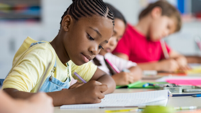 Schulm&auml;dchen schreibt in der Klasse