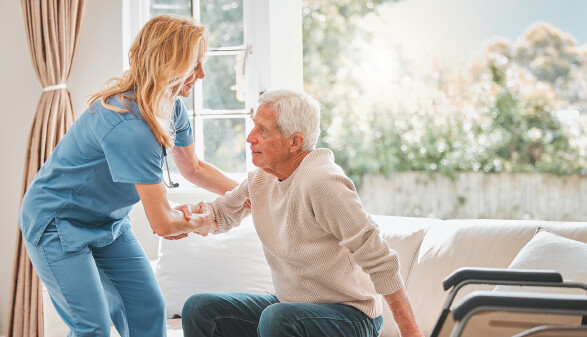 Plegerin hilft &auml;lterem Mann beim Aufstehen