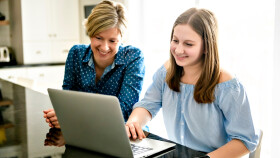 Mutter und Tochter sitzen vor einem Laptop
