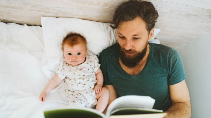 Papa liest seinem Kind ein Buch vor