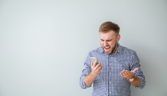 Mann schaut ver&auml;rgert auf sein Smartphone