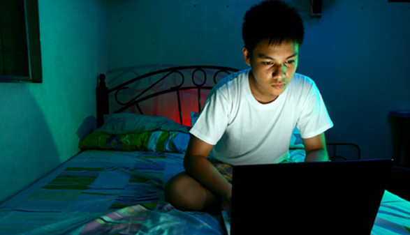 Jugendlicher mit Laptop auf dem Bett © Junpinzon, stock.adobe.com