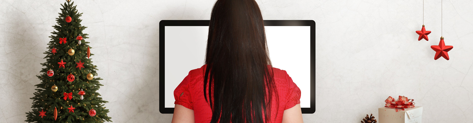 Eine Frau arbeitet am Computer. Auf dem Schreibtisch steht Weihnachtsdekoration.