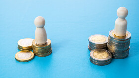 Konzept ungleicher Bezahlung am Arbeitsplatz zwischen M&auml;nnern und Frauen. Holzfiguren auf M&uuml;nzstapeln.