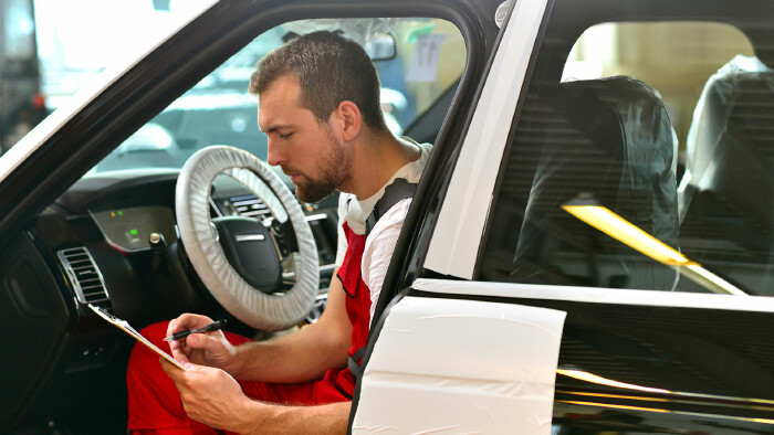 KFZ Mechaniker kontrolliert Auto